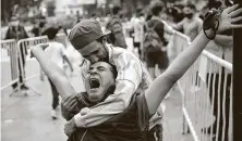  ?? Rodrigo Abd / Associated Press ?? Mourners embrace as they wait to see Maradona lying in state outside the presidenti­al palace in Buenos Aires, Argentina.