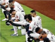  ??  ?? Astros players kneel while holding black pieces of fabric in support of the Black Lives Matter movement. Story on C3.