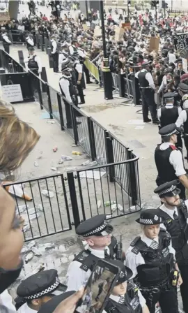  ??  ?? 0 Police form a cordon in Whitehall as thousands demonstrat­e in London. Right: protesters take the knee near the White House in Washington, DC, and at St Giles’ in Edinburgh