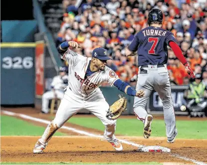  ?? Brett Coomer / Staff photograph­er ?? Nationals shortstop Trea Turner is called out at first after hitting the glove of Astros first baseman Yuli Gurriel.