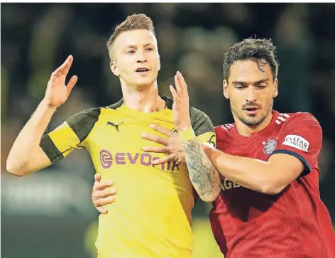  ?? FOTO: IMAGO ?? Echte Liebe: Marco Reus (Borussia Dortmund) wird von seinem früheren Mitspieler Mats Hummels (Bayern München) sehr zuvorkomme­nd in die Zange genommen.