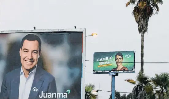  ?? MARCELO DEL POZO / Reuters ?? Carteles publicitar­ios del candidato a la reelección, Juanma Moreno, del PP, y Macarena Olona, de Vox
