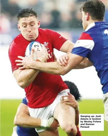  ??  ?? Ganging up: Josh Adams is tackled by Wesley Fofana and Damian Penaud