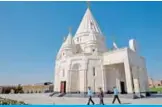  ??  ?? People walk past the new Yazidi Temple in the village of Aknalich, 35 kilometers from the Armenian capital Yerevan, which has seven domes topped with sun symbols represent the seven angels revered by the Yazidis, adherents of an ancient religion rooted in Zoroastria­nism. — AFP