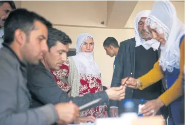  ?? AP ?? Voters wait for an electoral committee to check their documents inside a polling station in Diyarbakir, southeaste­rn Turkey, yesterday.