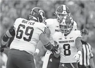  ?? ADAM HUNGER/AP ?? MSU receiver Jalen Nailor is congratula­ted by Blake Bueter after scoring a touchdown in the first half against Rutgers on Saturday in Piscataway, N.J.