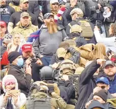  ?? BRODY | AP ROBYN STEVENS ?? In this Jan. 6, 2021 image from video provided by Robyn Stevens Brody, a line of men wearing helmets and olive drab body armor walk up the marble stairs outside the U.S. Capitol in Washington in an orderly single-file line, each man holding the jacket collar of the man ahead. The formation, known as “Ranger File,” is standard operating procedure for a combat team “stacking up” to breach a building.