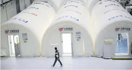  ?? AP PHOTO ?? NONSTOP
A man passes through Covid-19 test processing tubes in Beijing on Oct. 14, 2020. The country recently fired two officials after failing to avert the new onslaught of the deadly infection.