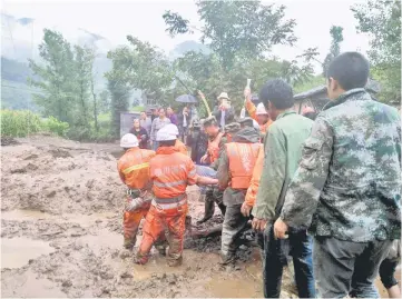  ??  ?? Rescuers carry a survivor at the site of a landslide in Puge in Sichuan province. — AFP photo