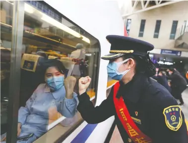  ?? STR/AFP VIA GETTY IMAGES ?? A train attendant gestures to medical staff in Nanchang leaving for Wuhan on Thursday. China’s foreign minister said Friday no other country would have been able to handle the epidemic as well as China has.