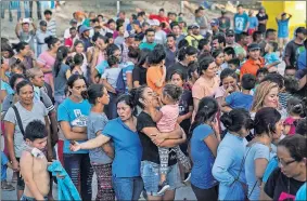  ?? [VERONICA G. CARDENAS/THE ASSOCIATED PRESS] ?? In this Aug. 30 photo, migrants, many who were returned to Mexico under the Trump administra­tion's “Remain in Mexico,” program, wait in line to get a meal in an encampment near the Gateway Internatio­nal Bridge in Matamoros.