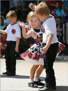  ?? FILE PHOTO NWA DEMOCRAT-GAZETTE ?? Lottie Pinkley waves to her family as she is spun by Jax Thomas Sept. 5, 2016, as they dance with Boots & Bows during the exhibition Square Dancing show at the annual Clotheslin­e Fair in Prairie Grove.