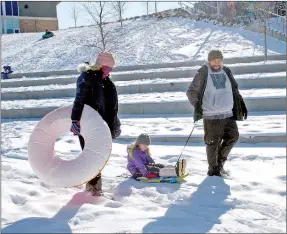  ?? Janelle Jessen/Siloam Sunday ?? Juliana Tufts (left), Carolina Tufts and Jason Tufts enjoy sledding in Memorial Park on Thursday.