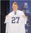  ?? WILLIE J. ALLEN JR./ASSOCIATED PRESS ?? Giancarlo Stanton shows off his new jersey during the MLB winter meetings in Orlando, Fla., Monday. Stanton was traded by the Marlins to the Yankees.