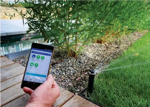  ?? Foto: dpa/Karl-Josef Hildenbran­d ?? Alexander Seufert zeigt auf seinem Smartphone eine App, mit der er die Bewässerun­g des Gartens steuern kann.