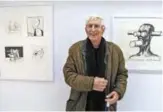  ??  ?? In this file photo taken on December 21, 2010 French cartoonist, artist and illustrato­r Tomi Ungerer poses in front of some of his drawings shown in an exhibition entitled “Politrics, le dessin politique de Tomi Ungerer” (Ungerer’s political drawings) at the Ungerer museum in Strasbourg, eastern France.