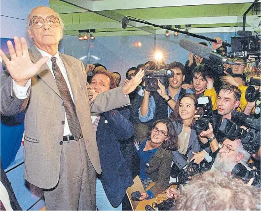  ?? AFP ?? En la Feria de Frankfurt, apenas conocida la noticia del Premio Nobel, Saramago rodeado de flashes en una rueda de prensa, octubre de 1998