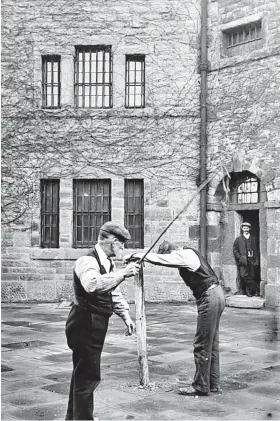  ?? ?? Not long before the prison was demolished, local photograph­er and practical joker Fred Little got a couple of chaps to pose at the old whipping post in the prison yard