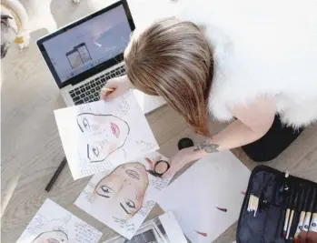  ??  ?? Brandi reviewing mock-ups for a makeup app at her Toronto apartment in December 2015