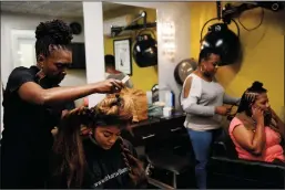  ?? DANIA MAXWELL/LOS ANGELES TIMES ?? Kari Williams, left, who is an expert in hair and scalp care, said that common methods of straighten­ing or chemically treating black hair often damage the hair and scalp.