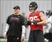  ?? CURTIS COMPTON/CCOMPTON@AJC.COM ?? Falcons tight end Eric Saubert and head coach Dan Quinn watch a play during organized team activities last month in Flowery Branch.