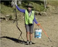  ??  ?? Volunteer Jan Anderson holds up a strap she pulled from the sand on Wednesday near the boat ramp at Boulder Reservoir.