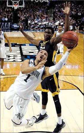  ?? AP/CHARLES KRUPA ?? Villanova’s Jalen Brunson (1) drives past West Virginia’s Wesley Harris during the first half of the East Regional semifinals in the NCAA Tournament at the TD Garden in Boston. The Wildcats won 90-78 to advance to Sunday’s regional final.