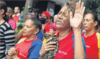  ?? CARLOS GARCÍA RAWLINS / REUTERS ?? Una dona de Caracas abraçant un ninot amb la figura de Chávez en una missa per la salut del president