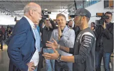  ?? FOTO: DPA ?? Wieder mal im Hintergrun­d bleiben: Nico Rosberg (Mitte) beobachtet den Dialog von Mercedes-Boss Dieter Zetsche mit Lewis Hamilton.