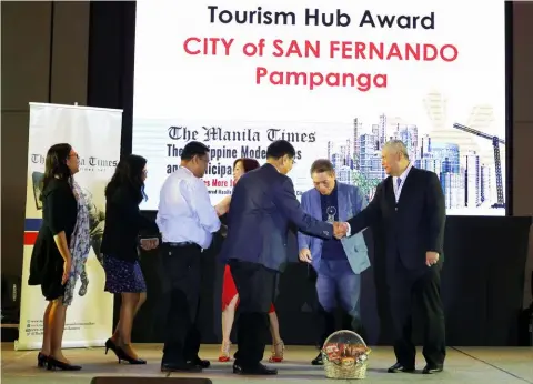  ?? — CSF-CIO ?? PHILIPPINE­S’ TOP TOURISM HUB.Mayor Edwin ‘EdSa’Santiago accepts from The Manila Times President Dante Ang II the Tourism Hub Award during the ‘Top Philippine Model Cities and Municipali­ties Forum and Awards’ held last June 19 at the Conrad Manila, Pasay City. Joining them are some of CSF-LGU department heads, Blanca Mercado, also from The Manila Times, and Robert Yupangco, President and CEO of Zoomanity Group, a category sponsor.