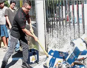  ??  ?? Making hispoint: Jamal smashing the cartons of beer outside the building’s gate.