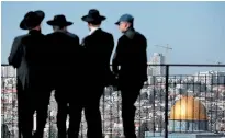  ??  ?? Ultra Orthodox Jews look at the city of Jerusalem from the Mount of Olives. Dome of the Rock mosque is on the right. AFP