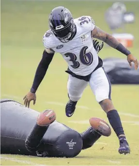  ?? KARL MERTON FERRON/BALTIMORE SUN ?? Ravens safety Chuck Clark flattens a tackling dummy Wednesday during a practice session. On Friday, he and fellow safety Earl Thomas III got into a dust-up at training camp.