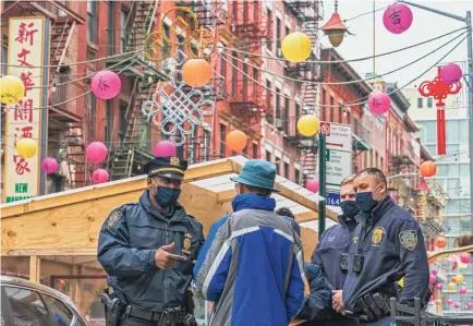  ?? MARY ALTAFFER/AP ?? Capt. Tarik Sheppard, left, of the New York Police Department’s Community Affairs Rapid Response Unit talks to a resident while on an outreach patrol in the Chinatown neighborho­od of New York on Wednesday.