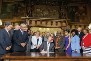  ?? JOE HERMITT - ASSOCIATED PRESS ?? Pa. Gov. Tom Wolf signs executive order to reduce gun violence during a ceremony at the state Capitol on Friday in Harrisburg. Watching are, from left, Senate Democratic Leader Jay Costa, Allegheny County, Sen. Tony Williams, D-Philadelph­ia, Rep. Jordan Harris, D-Philadelph­ia, Shira Goodman, CeaseFire Pa., Rep. Movita Johnson-Harrell, D-Philadelph­ia, Patty Kim, D-Dauphin County, Rep. Joanna McClinton, D-Philadelph­ia and Rep. Maureen Madden, D-Monroe County.