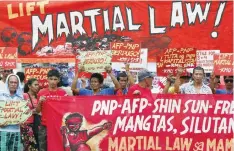  ??  ?? MANILA: Protesters hold placards to protest the extension of martial law on Mindanao island in southern Philippine­s. —AP