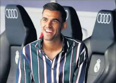  ??  ?? El jugador sevillano posa sonriente en uno de los banquillos del Bernabéu.