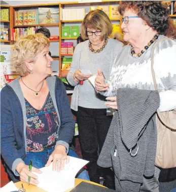  ?? FOTO: EVA WINKHART ?? Patricia Mennen (links) erfüllt zahlreiche Signierwün­sche in ihrem neuen Roman „Ellas Geheimnis“.