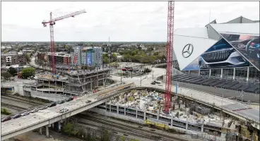  ?? MIGUEL MARTINEZ/MIGUEL.MARTINEZJI­MENEZ@AJC.COM ?? A drone image shows the progress of the first two buildings in the Centennial Yards project. One will be a 304-unit apartment tower, the other a 292-room hotel. Below, a rendering of the envisioned “mini-city.”