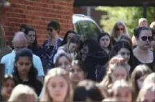  ??  ?? Colleagues and pupils of teacher James Furlong stand together to take part in a period of silence Monday at the Holt School in Wokingham, England, in memory of Mr. Furlong, one of the victims of a Saturday terror attack in nearby Reading.