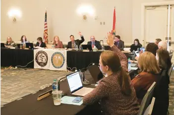  ?? RICARDO RAMIREZ BUXEDA/AP ?? Members raise their hands during a vote in a joint board meeting of the Florida Board of Medicine and the Florida Board of Osteopathi­c Medicine on Nov. 4 in Lake Buena Vista to establish new guidelines limiting gender-affirming care in Florida.