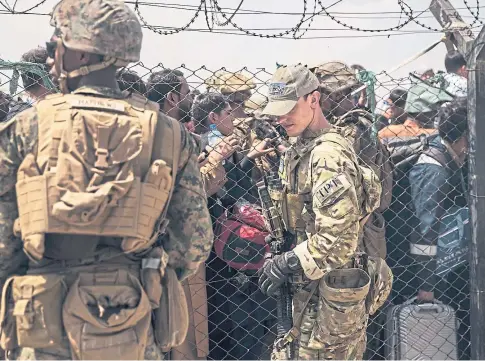  ??  ?? RACE AGAINST TIME: American service personnel provide assistance during the evacuation at Kabul airport.