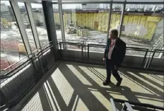  ?? Darrell Sapp/Post-Gazette ?? Principal Patrick Myers walks along the staircase at Chartiers Valley High School in Collier. In the background is the former cafeteria that is awaiting demolition. “The space is incredibly flexible,” Mr. Myers said of the school’s new additions.