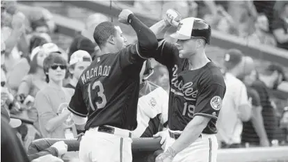  ?? KARL MERTON FERRON/BALTIMORE SUN ?? The Orioles’ Manny Machado celebrates back-to-back solo home runs with Chris Davis against the Houston Astros at Oriole Park at Camden Yards in August. This was a season of home runs, high hopes and ultimate defeat.