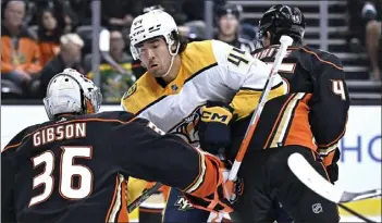  ?? ALEX GALLARDO – THE ASSOCIATED PRESS ?? Ducks goaltender John Gibson catches the puck as defenseman Colton White, right, blocks Nashville's Kiefer Sherwood.