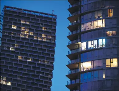  ?? DARRYL DYCK, THE CANADIAN PRESS ?? A man stands in the window of an upper-floor condo in Vancouver. A new report from Statistics Canada shows women, members of dual-income families and people with higher education are more likely to be able to work from home and less likely to suffer a loss of income due to measures to limit spread of the coronaviru­s.