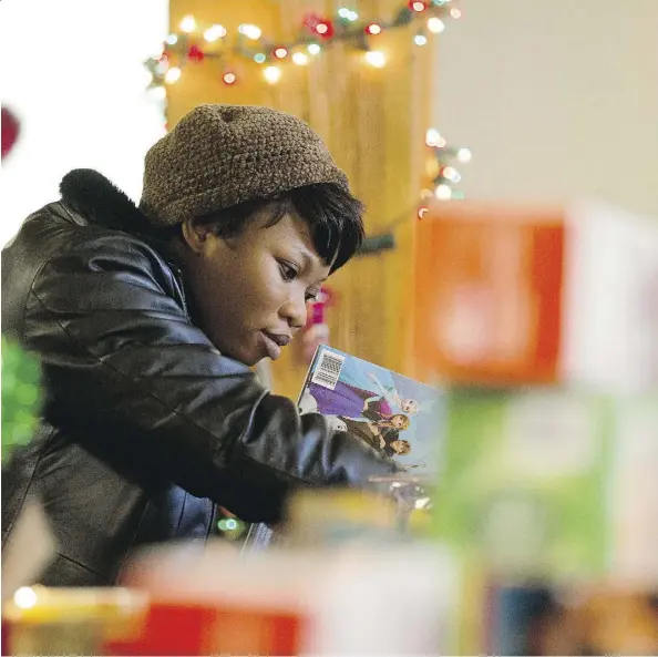  ?? DAVID BLOOM ?? A woman looks through the selection of children’s presents during the Bissell Centre’s Festive Giveaway on Monday. Families have until Wednesday to come into the centre to choose a few things for youngsters to find under the tree.