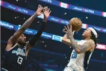  ?? ALLISON DINNER/AP ?? Magic guard Markelle Fultz , right, shooting the ball against L.A. Clippers forward Paul George, picked up his scoring down the stretch in Saturday’s win.