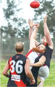  ??  ?? Nilma-Darnum player Liam Van Eyk flies for a mark to get his hands to the ball first ahead of his Nyora opponent Timothy Miller who was determined to punch the ball away.