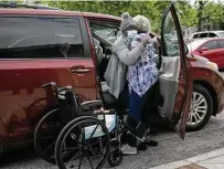  ??  ?? Eliza Bellesen helps her aunt, Rhoda Cubit, 87, out of the car and into her wheelchair for Cubit’s appointmen­t to get her second dose of the COVID-19 vaccine at Bethel AME Church.